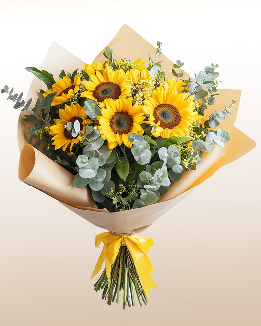 A bright and elegant sunflower bouquet arranged with fresh seasonal greens. A radiant, modern design delivered worldwide with care.