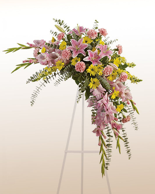 Memorial flower arrangement with lilies, carnations, and yellow blooms. A graceful tribute delivered across the USA.