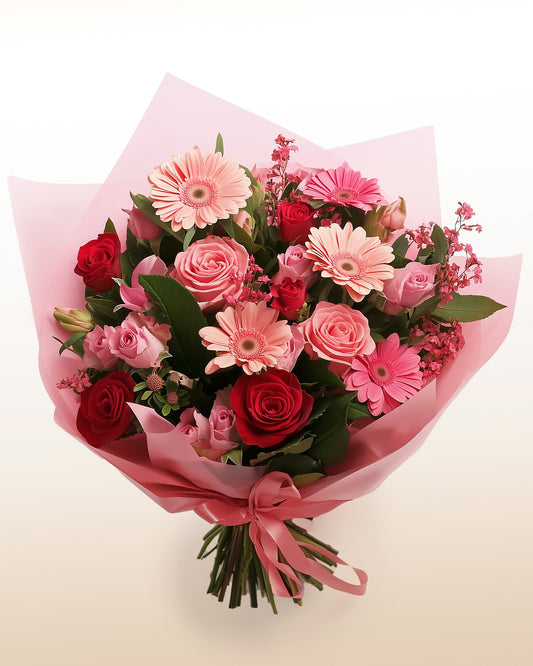 A joyful bouquet of roses and gerberas in soft and vibrant pinks. Fresh, modern, and handcrafted.